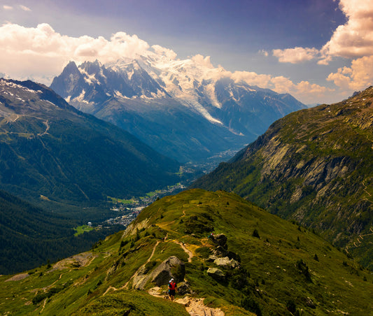 Hikers on a green alpine trail below snowy peaks, Mont Blanc region