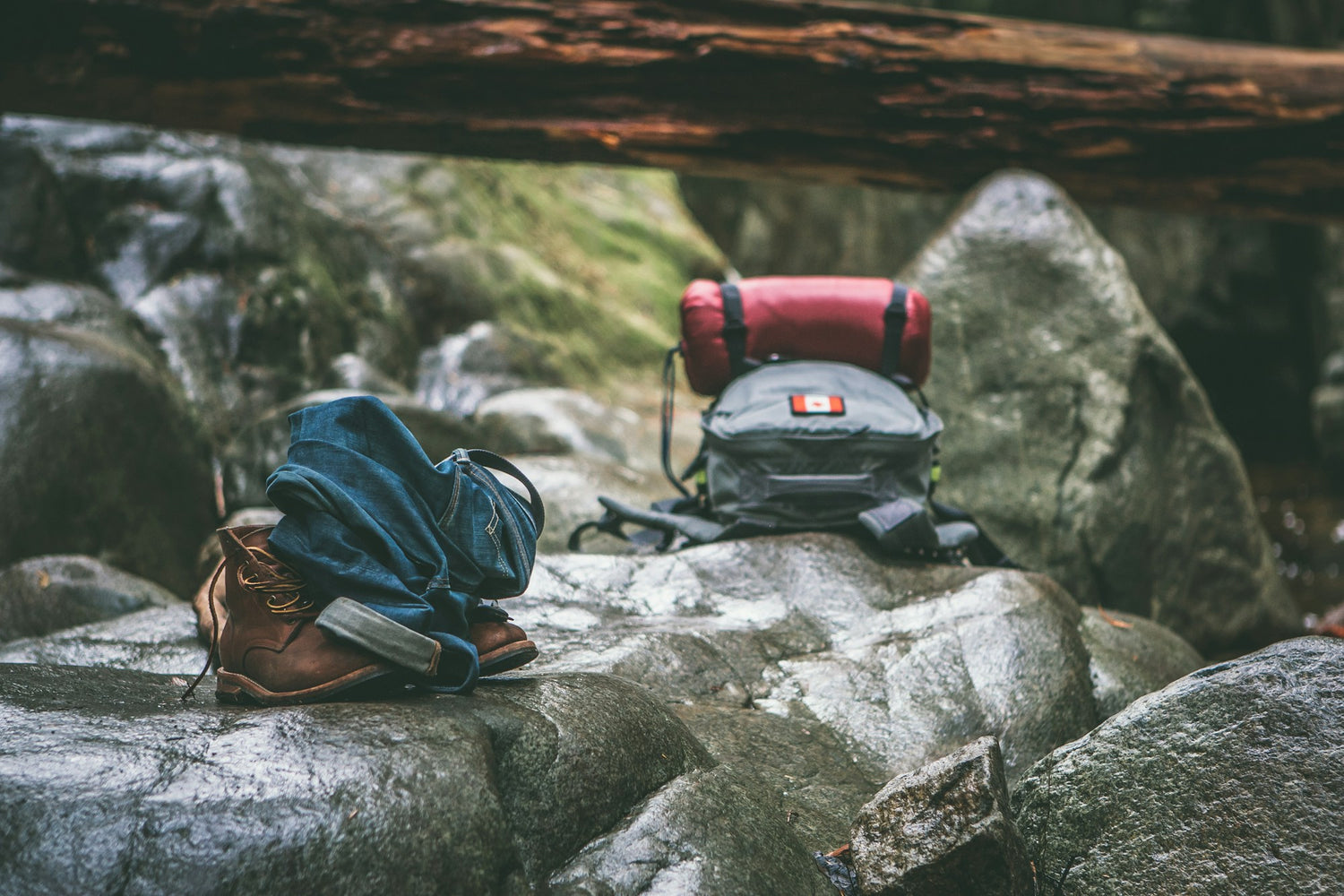 Two hiking backpacks resting on grey rock in daylight