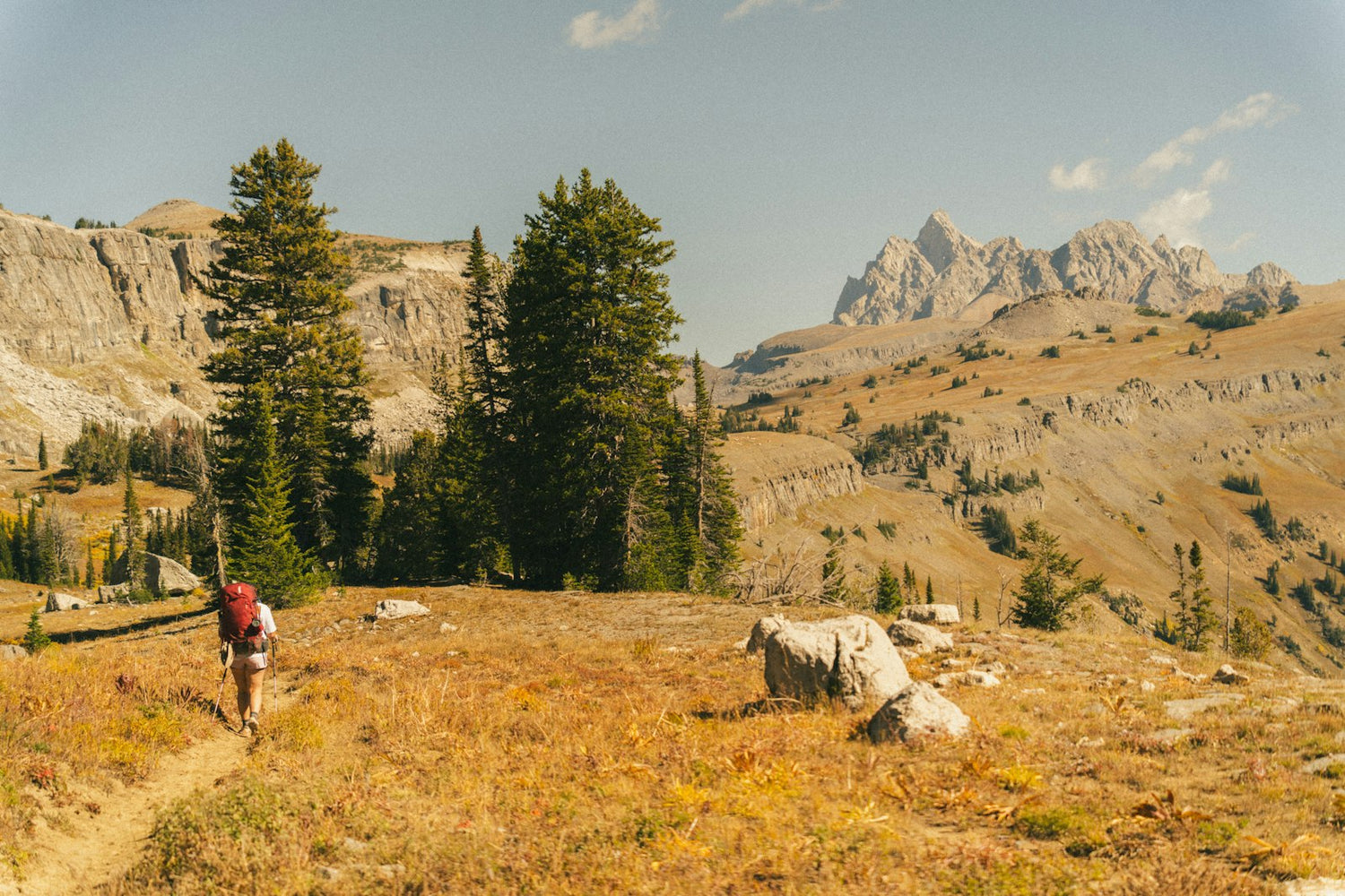 Backpacker hiking a mountain trail with a loaded pack in fall colors