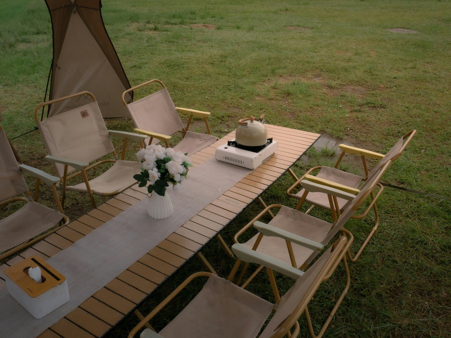 Outdoor camping table and chairs set up on grass