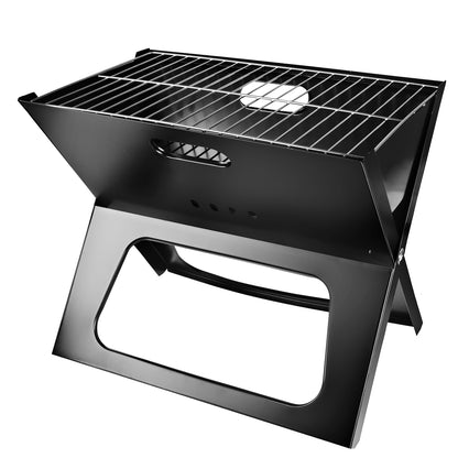 Portable folding charcoal BBQ grill standing on fold-out legs